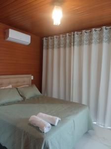a bedroom with a bed with a white curtain at Urubici Maravilhas da Serra 2 in Urubici