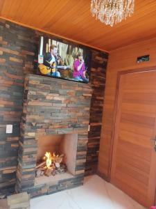 a fireplace with a tv on top of it at Urubici Maravilhas da Serra 2 in Urubici