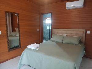 a bedroom with a large bed with a mirror at Urubici Maravilhas da Serra 2 in Urubici