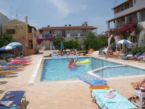 a pool with chairs and a girl in a raft in it at Likourgos Beach in Kavos
