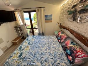 Schlafzimmer mit einem Bett mit blauer Blumenbettdecke in der Unterkunft Oasi del Relax - Seaside Peaceful Panoramic Terrace in ITALY - new Sardinia apartment 50 mt beach&sea full comfort air conditioning-WiFi-Parking-Privacy in Torre Dei Corsari