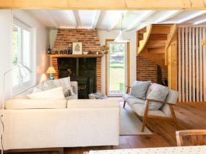 a living room with a couch and a brick wall at Holiday Home La Grange du Belon by Interhome in Saint-Julien-en-Born