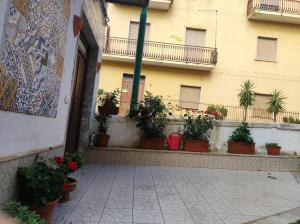 a courtyard with potted plants in front of a building at ngopp a via nova in Agropoli
