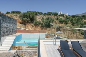 a swimming pool with chairs and a volley ball at New Villa Paradosiako with private pool and BBQ near to the Beach in Sellía +39 photos