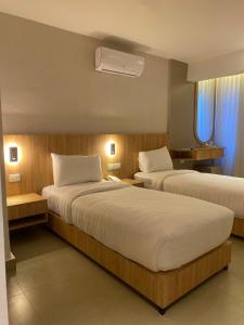 a hotel room with two beds and a fan at Gardens Hotel in Amman