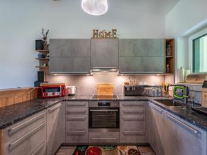 a kitchen with stainless steel appliances and gray cabinets at Holiday Home Sonnenteich-Haus by Interhome in Goritschach