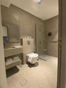 a bathroom with a toilet and a sink and a shower at Gardens Hotel in Amman