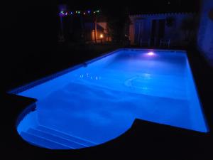 una piscina por la noche con iluminación azul en Vila Johanna, en Lagos 8 fotos más