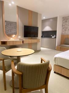 a hotel room with a bed and a table and a bedroom at Gardens Hotel in Amman