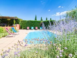 una piscina in un giardino con fiori viola di Holiday Home Villa Camilia by Interhome a Figanières