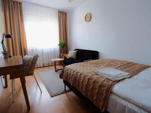 sypialnia z łóżkiem, biurkiem i krzesłem w obiekcie Apartamenty Vega w Charzykowach