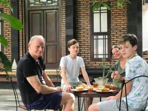 a group of people sitting around a table eating food at Lotus 2 Guest House in Borobudur