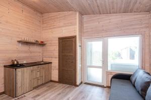 a room with wooden walls and a large window and a couch at 83 Pylimas Šventoji in Šventoji