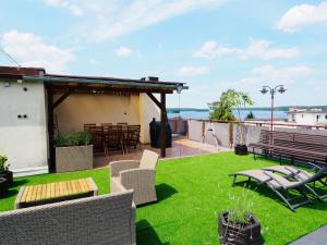 patio z trawą i krzesłami na dachu w obiekcie Apartamenty Vega w Charzykowach