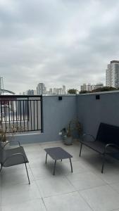 a patio with chairs and a table on a balcony at Stúdio 81 Tatuapé Aconchegante in Sao Paulo
