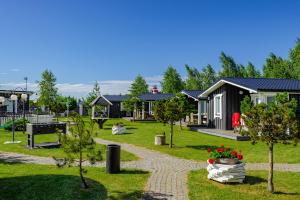 a row of houses in a park with plants and flowers at 83 Pylimas Šventoji in Šventoji