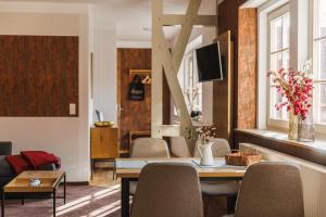 a living room with a table and chairs and a couch at Gut Beinrode in Kallmerode
