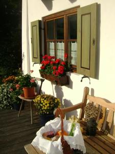 a porch with a bench and flowers in a window at Ferienwohnung Wein in Berchtesgaden