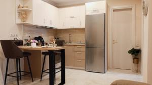 a kitchen with a stainless steel refrigerator and a table at Coolio's home in Ágios Rókkos