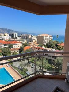 balcone con vista sulla città e sulla piscina di Nuovo appartamento vista mare a Roquebrune-Cap-Martin