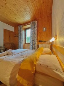 une chambre avec deux lits dans une pièce dans l'établissement Gîte et chambres d'hôtes "La Tourtette" 12 pers, à Saint-Étienne-en-Dévoluy