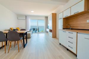 a kitchen and dining room with a view of the ocean at Villa ANABELLA in Elshani