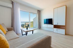 a living room with a couch and a tv at Villa ANABELLA in Elshani