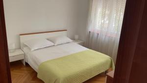 a bedroom with a white bed and a window at Lorena Apartment in Šibenik