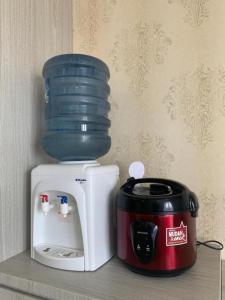 a coffee maker and a toaster on a shelf at TheTra Homestay in Sunggal