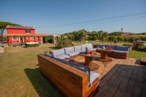 a patio with couches and tables and a playground at Agriturismo L'Istrice di Giò in Montalto di Castro