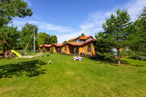 a large yard with a house and a playground at Fetingas in Šventoji