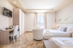 a hotel room with two beds and a desk and a table at Dei del Mare Extra Luxury in Gallipoli