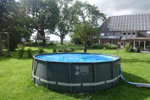 a large hot tub in a yard next to a house at Urlaub auf dem Janssenhof in Sankt Michaelisdonn