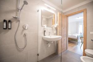 a bathroom with a shower and a sink and a toilet at Hotel Lago della Creta in San Vigilio Di Marebbe +92 photos