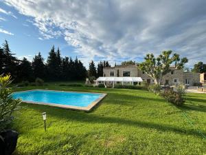 a yard with a swimming pool in front of a house at La petite plaine in Clansayes