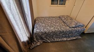 a small bedroom with a bed with a comforter at Studio Villa Monica in Vallauris