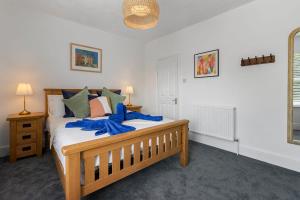 a bedroom with a bed with a blue ribbon on it at Maple House - Park View Sleeps 7 in Exeter