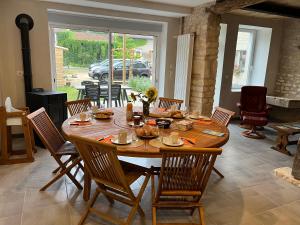 a wooden table in a living room with chairs and a dining room at au point du jour Ch3 in Récourt-le-Creux