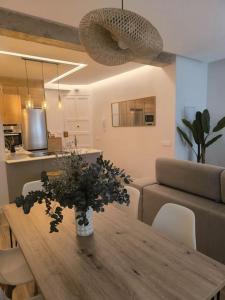 a living room with a wooden table with flowers on it at El Sueño de Luca, Parking gratuito centro in Logroño