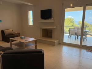a living room with a fireplace and a tv at The Theologos Guesthouse in Theologos