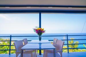a table with a vase of flowers on a balcony at Iotape Hotel Antalya in Işıklı