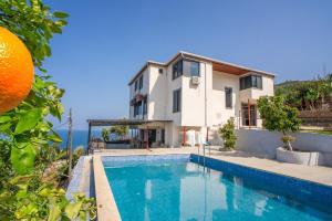 a villa with a swimming pool in front of a house at Iotape Hotel Antalya in Işıklı