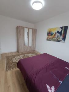 une chambre avec un lit violet et un miroir dans l'établissement Pesacka Zona Apartment, à Novi Pazar