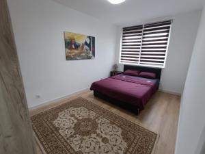 une chambre avec un lit violet et une fenêtre dans l'établissement Pesacka Zona Apartment, à Novi Pazar