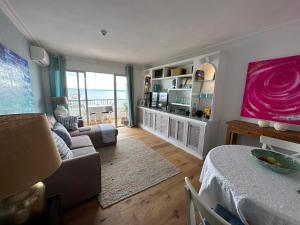 a living room with a couch and a television at Beach Apartment with Stunning View in Can Pastilla