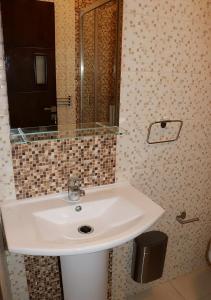 een badkamer met een witte wastafel en een spiegel bij Résidence riad al andalos in Nador