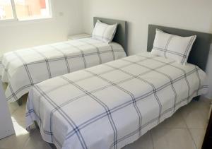 twee bedden naast elkaar in een kamer bij Résidence riad al andalos in Nador