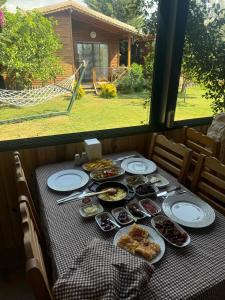 a table with plates of food on a table with a window at EM-BA BUTİK BUNGALOV in Demre