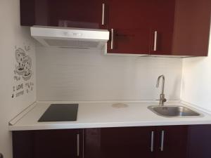 a kitchen with brown cabinets and a sink at La casa sulla piazza in Cerda