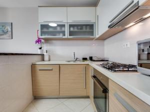 cocina con paredes blancas y armarios de madera en Apartment Relax-3 by Interhome, en Jasenice